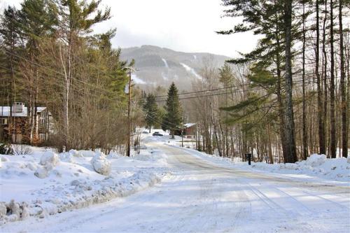 a road covered in snow with trees and houses at South Londonderry Home, Walk to Magic Mtn Ski Area in Londonderry