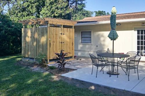 a patio with a table and chairs and a fence at Vibrant Pass Christian Oasis - 3 Blocks to Beach! in Pass Christian