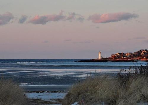 a lighthouse on an island in a body of water at Elegant Gloucester Beach Getaway with Ocean Views! in Gloucester