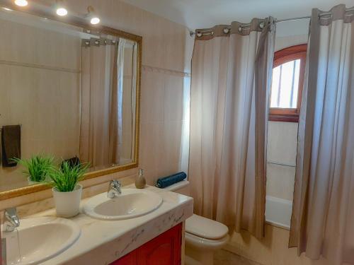 een badkamer met een wastafel, een toilet en een spiegel bij ALIZUTH VILLA in Puerto del Carmen