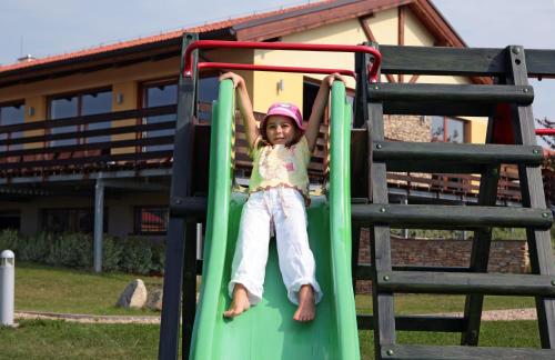 a little girl on a slide at a playground at Wellness Hotel Happy Star in Hnanice