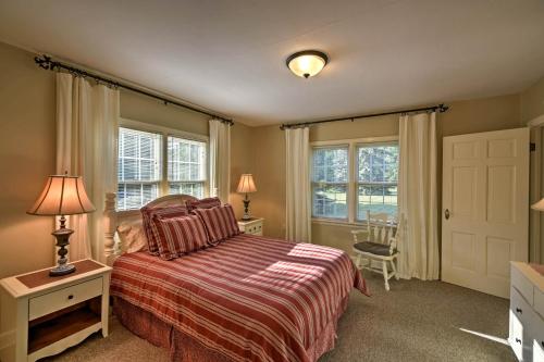 a bedroom with a bed and two windows and a door at Family-Friendly Fish Creek Cape House with Fire Pit in Fish Creek