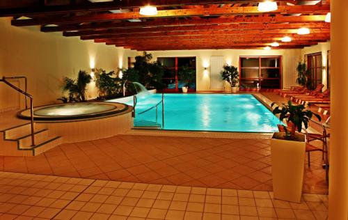 a large pool with a hot tub in a building at Wellness Hotel Happy Star in Hnanice
