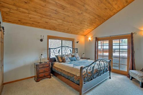 a bedroom with a bed and a wooden ceiling at Cabin on Rainbow Lake Views, Hot Tub and Dock in Pinetop-Lakeside