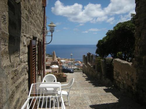 a white bench sitting on a street with a view of the ocean at Residence Timeo in Ustica