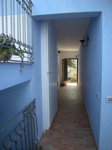a hallway with a blue wall and a staircase at Residence Timeo in Ustica