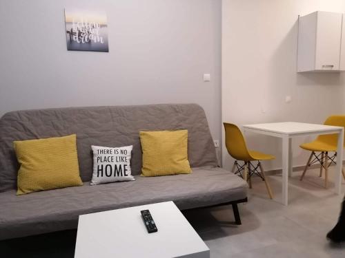 a living room with a gray couch and yellow pillows at Central City Kristalli studio in Thessaloniki