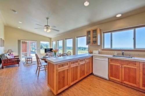 a kitchen with wooden cabinets and a living room at Sequim Cottage with Panoramic Olympic Mtn Views! in Sequim