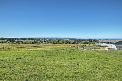 a large field of grass with a house in the background at Sequim Cottage with Panoramic Olympic Mtn Views! in Sequim