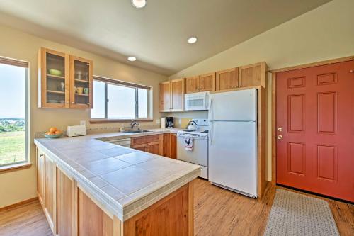a kitchen with a white refrigerator and a red door at Sequim Cottage with Panoramic Olympic Mtn Views! in Sequim