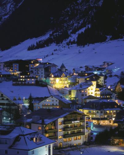a city lit up at night in the snow at Hotel Vista Allegra in Ischgl