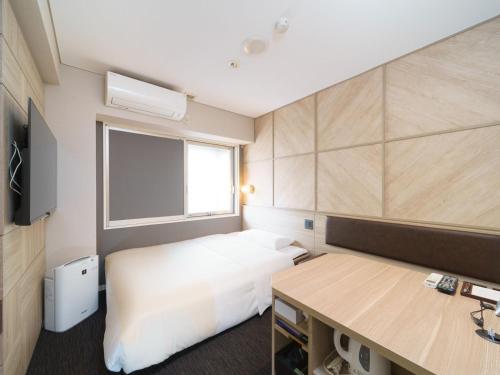 a small room with a bed and a desk at Super Hotel Midosujisen Esaka in Suita
