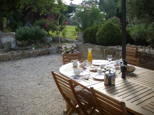 a wooden table with plates and glasses on it at Domaine Lafayette in Loriol-du-Comtat