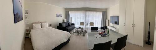 a bedroom with a bed and a living room at Studio De Strandsuite in Ostend