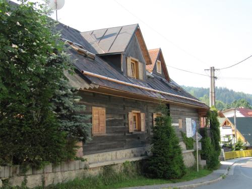 an old wooden house on the side of a street at Drevenica u Holtana in Oščadnica