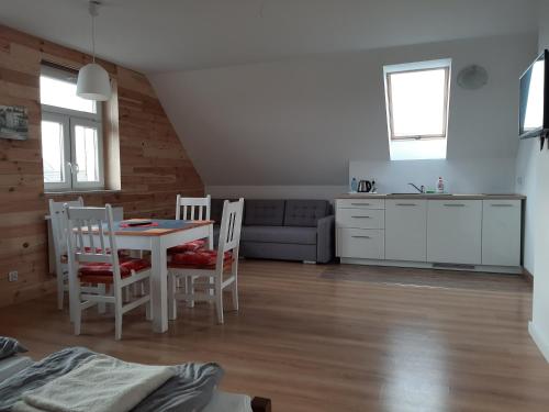 a kitchen and living room with a table and chairs at Dom Piotra in Goniadz