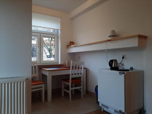 a small kitchen with a desk and a table with a chair at Dom Piotra in Goniadz