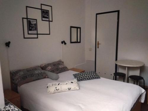 a bedroom with a white bed and a table at Mister Hostel in Lviv