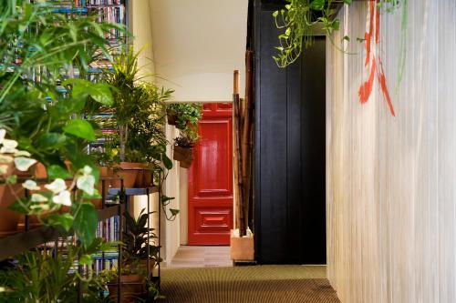 a red door in a hallway with plants at Praktik Garden in Barcelona