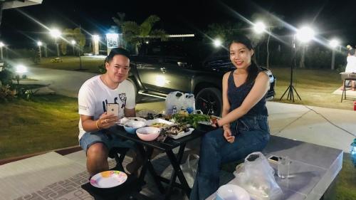 a man and a woman sitting at a table with food at Panutsaya Homestay in Wang Nam Khieo