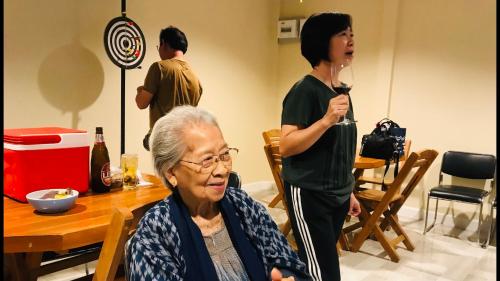 a woman is taking a picture of an older woman at Panutsaya Homestay in Wang Nam Khieo