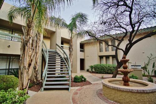 a building with a staircase and a fountain in front at Walk to Fashion Park! Phoenix Abode with Pool Access in Phoenix