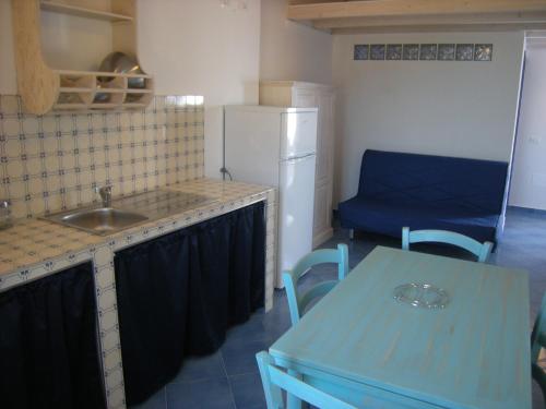 a kitchen with a sink and a table and a refrigerator at Residence Timeo in Ustica