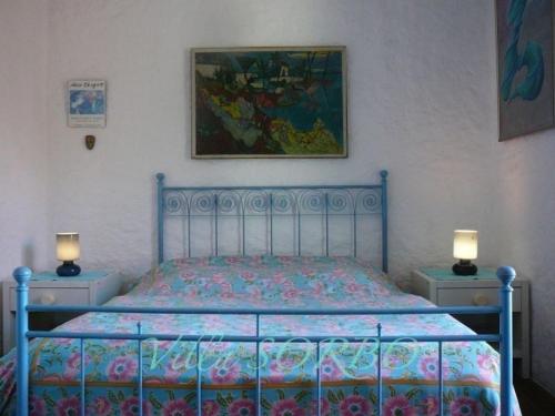 - une chambre avec un lit bleu et 2 tables de nuit dans l'établissement Villa Sorbo, à LʼÎle-Rousse