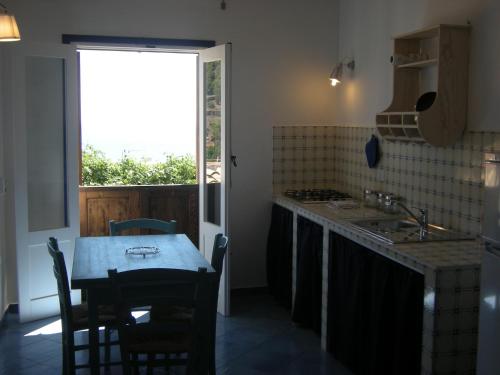 a kitchen with a table and a sink and a window at Residence Timeo in Ustica