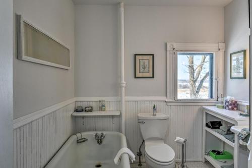 a bathroom with a tub and a toilet and a sink at Historic Backus Home, Steps to Pine Mountain Lake! in Oshawa