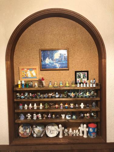 a shelf with lots of figurines on it at Pension Moomin Papa in Myoko