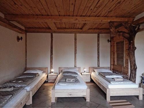 2 camas en una habitación con techos de madera en Pokoje do wynajęcia, en Nowogrodziec