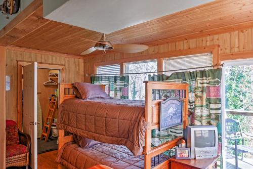 a bedroom with a bed and a tv in a room at Paradise Cove Cabin with Boathouse and Dock in Guntersville