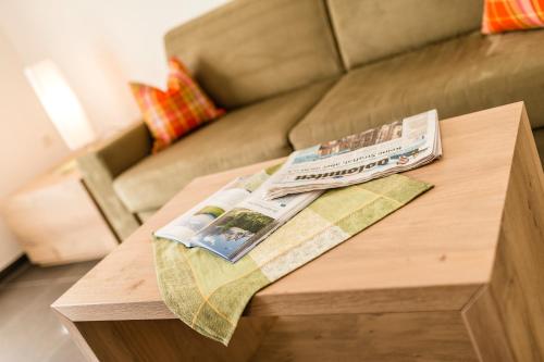 two newspapers on a coffee table in front of a couch at Beim Dorner in Schenna