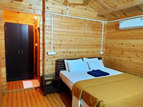 sypialnia z łóżkiem w drewnianym domku w obiekcie Agonda Paradise w mieście Agonda