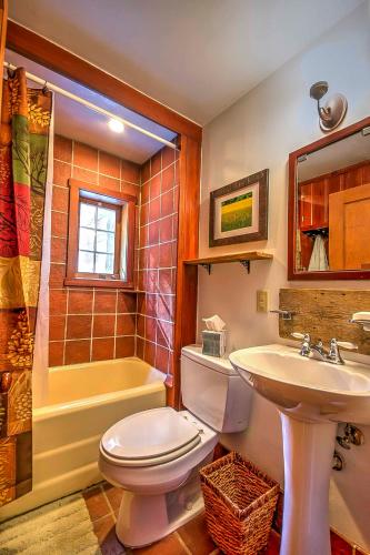 Un baño con inodoro, lavabo y bañera. en Award-Winning Log Cabin, Top 5 in New England!, en Londonderry