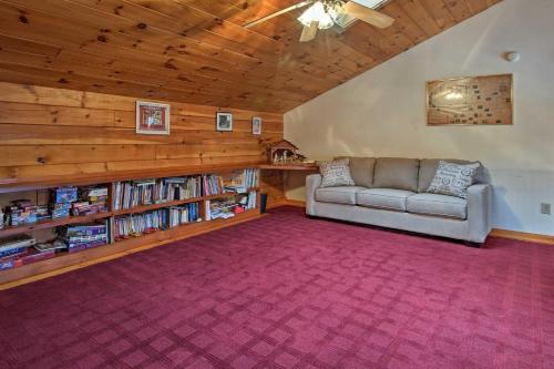 a living room with a couch and book shelves at Spacious Gilford Retreat with Deck 2 Mi to Skiing! in Gilford