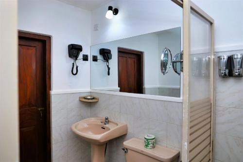 un bagno con lavandino e specchio di Camellia Dwelling a Hikkaduwa