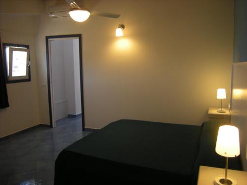 a bedroom with a bed and two lights on the wall at Residence Timeo in Ustica