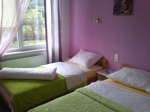 two beds in a room with a window at Motel Maks in Kiseljak
