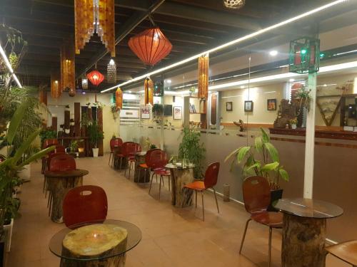 un restaurante con mesas, sillas y macetas en Au Lac Hotel, en Bến Cát