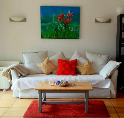 a living room with a white couch with red pillows at Casa Sol with private terrace, garden, pool, beautiful view in Port de Soller