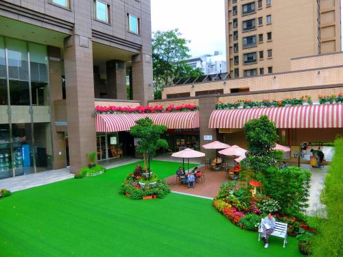 an overhead view of a building with a green lawn and flowers at K Hotel Taipei in Taipei