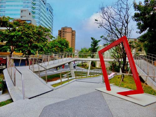 a bridge in a city with red metal sculptures at K Hotel Taipei in Taipei