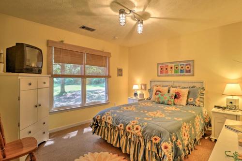 um quarto com uma cama, uma televisão e uma janela em Cozy Pine Mountain Cabin with Screened Porch and Yard! em Pine Mountain