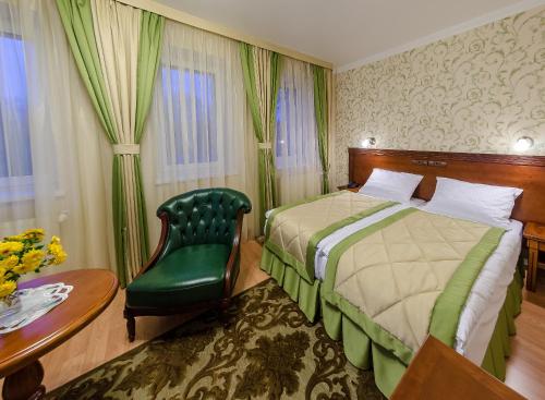 a hotel room with a bed and a chair and a table at Bystrytsya Lux in Ivano-Frankivsʼk