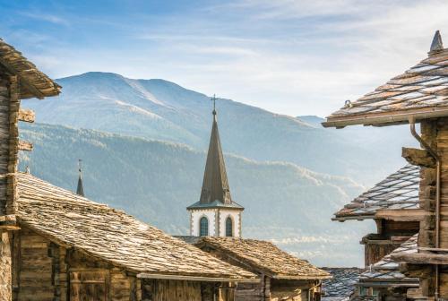 a view of a church with mountains in the background at VISPERBLICK 24-7 Parkplatz und Frühstück inkl in Ausserberg
