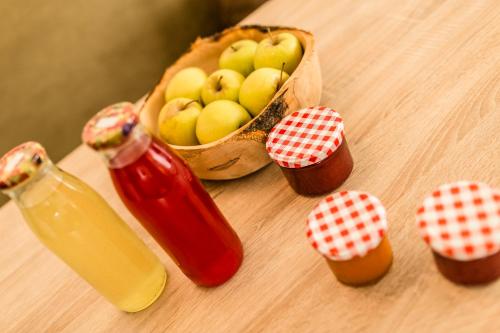 una cesta de manzanas y una botella de zumo en una mesa en Beim Dorner, en Scena