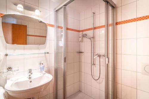 a bathroom with a sink and a shower at VISP erblick H O T E L AUSSERBERG & Late Check-in in Ausserberg