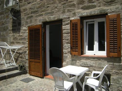 a table and chairs in front of a stone building at Residence Timeo in Ustica
